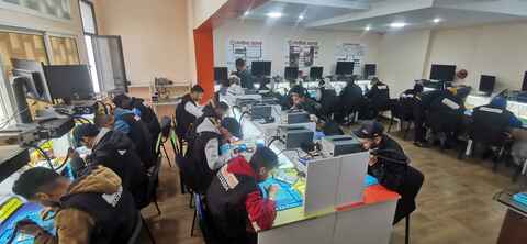 Students practicing smartphone repair in the Phone Genie Centre classroom in Rabat
